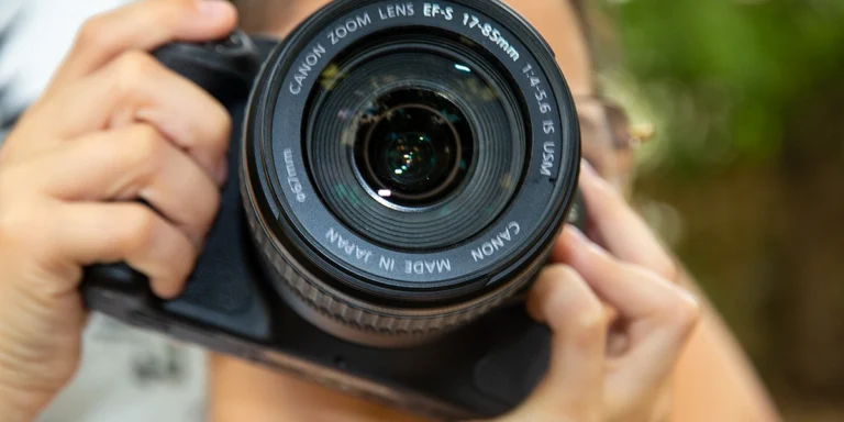 ילד מחזיק מצלמה מקצועית בסדנת צילום לילדים