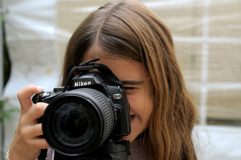 סדנת-צילום-לילדים--ילדה-מצלמת-עם-מצלמה-מקצועית