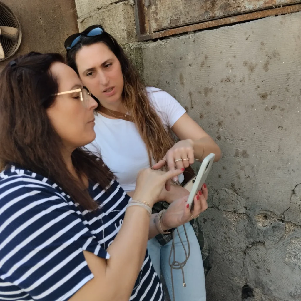משתתפות בודקות תמונות בטלפון בסדנת צילום בסמארטפון